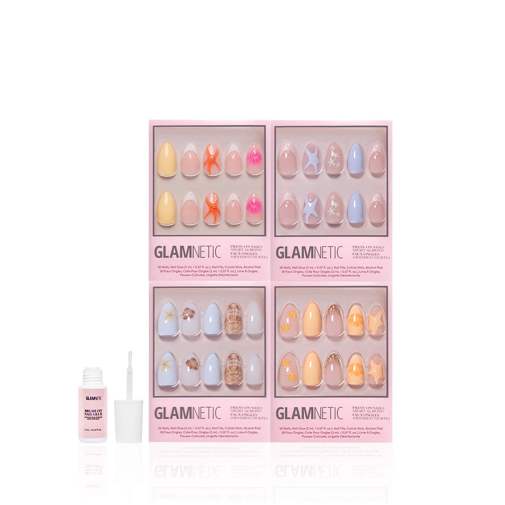 Four boxes of glamnetic Coastal Keepsakes press-on nails in pastel designs, some with starfish nail art, are arranged in a grid. In front is a small white bottle of glamnetic brush-on nail glue with the cap off and brush visible against a white background. - Product image
