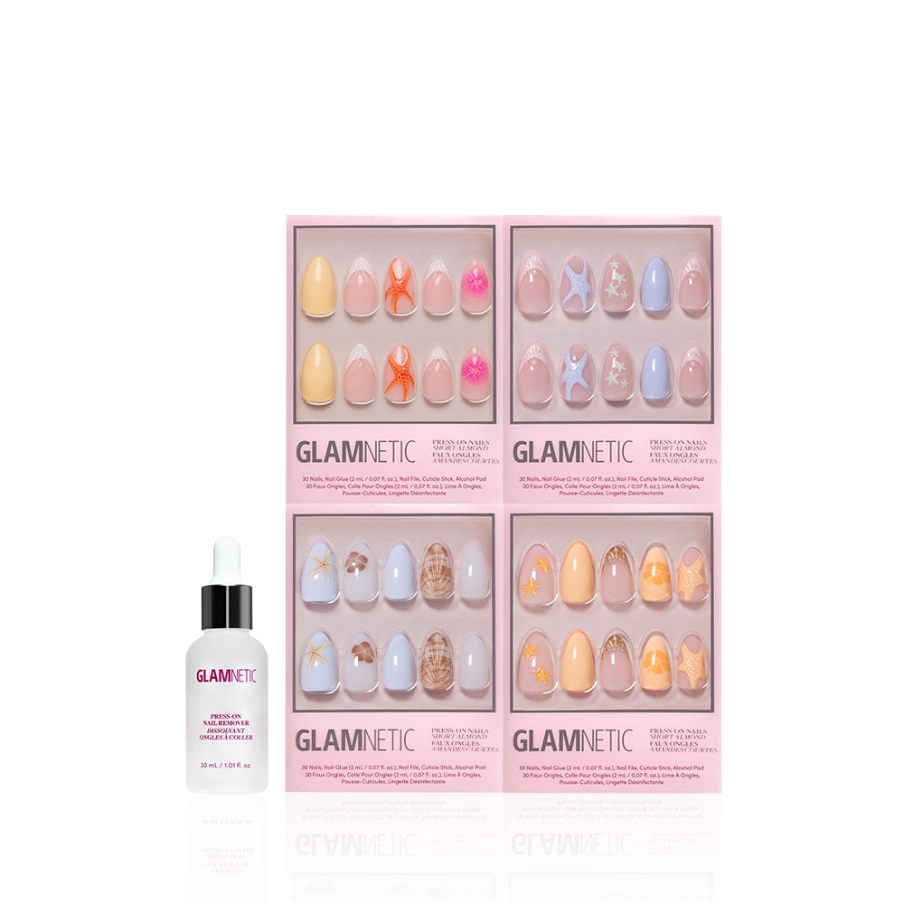 A bottle of glamnetic cuticle oil stands beside four glamnetic press-on nail boxes, each with vibrant pastel designs. One box features the "Coastal Keepsakes" set, showcasing delicate seashell nail art on a white background. - Product image