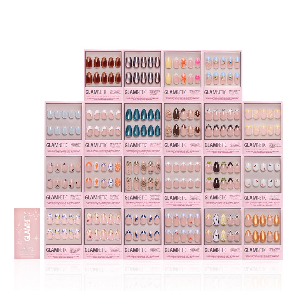 A collection of glamnetic Euro Summer Collection press-on nails in pink packaging, arranged in rows, features salon-quality boxes with assorted nail designs. One glamnetic box lies flat to the left. - Product image