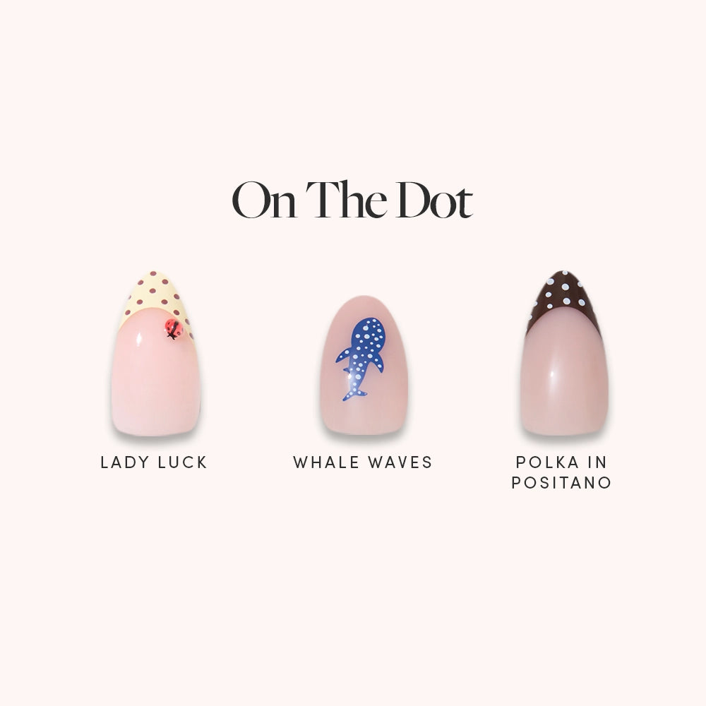 On The Dot by glamnetic features three short almond press-on nails: Lady Luck (beige with red ladybug), Whale Waves (blue with white-dotted whale), and Polka in Positano (dark brown with white dots).