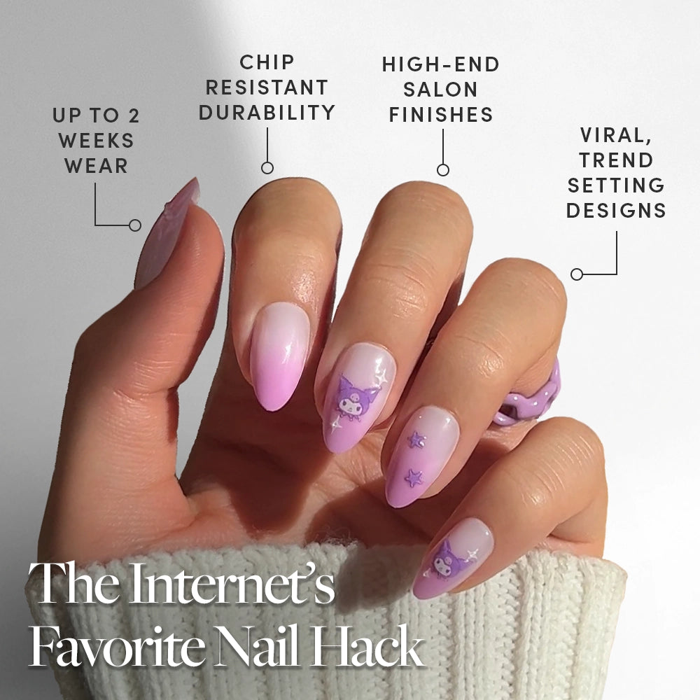 A hand with long, almond-shaped nails showcases glamnetic's Kuromi™ set: a pink and lilac ombre manicure with cute cartoon and 3D accents. Enjoy up to 2 weeks' wear, chip resistance, high-end finish, and viral designs. Sweater sleeve in view. - Product image