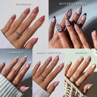 Five manicured hands display glamnetic’s Almond Atelier nail sets in various styles: STARBEAM, BUTTERFLY EFFECT, CLASS ACT, BARELY SPOTTED, and SANDED.