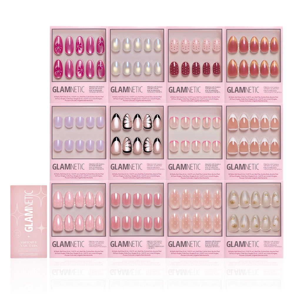 Twelve sets of glamnetic’s The Spring Edit Collection press-on nails, in pink boxes with various shapes, colors, and shimmery designs, are arranged in a grid beside a pink nail application kit on the lower left. - Product image