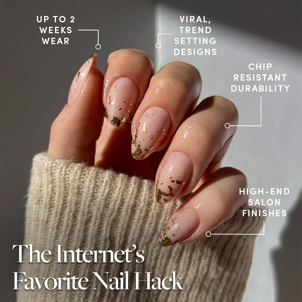 A hand with long, almond-shaped nails shows off glamnetic's 24K gold foil nail set in a nude polish with gold tips. Enjoy up to 2 weeks of chip-resistant wear, trend-setting designs, and a salon-quality finish. - Product image