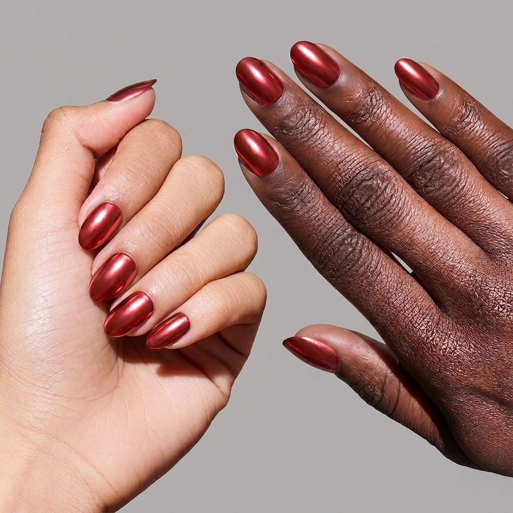 Two hands—one light-skinned, one dark-skinned—display almond-shaped nails polished in glamnetic’s Cherry Glaze, a shiny metallic red, set against a neutral background. - Product image