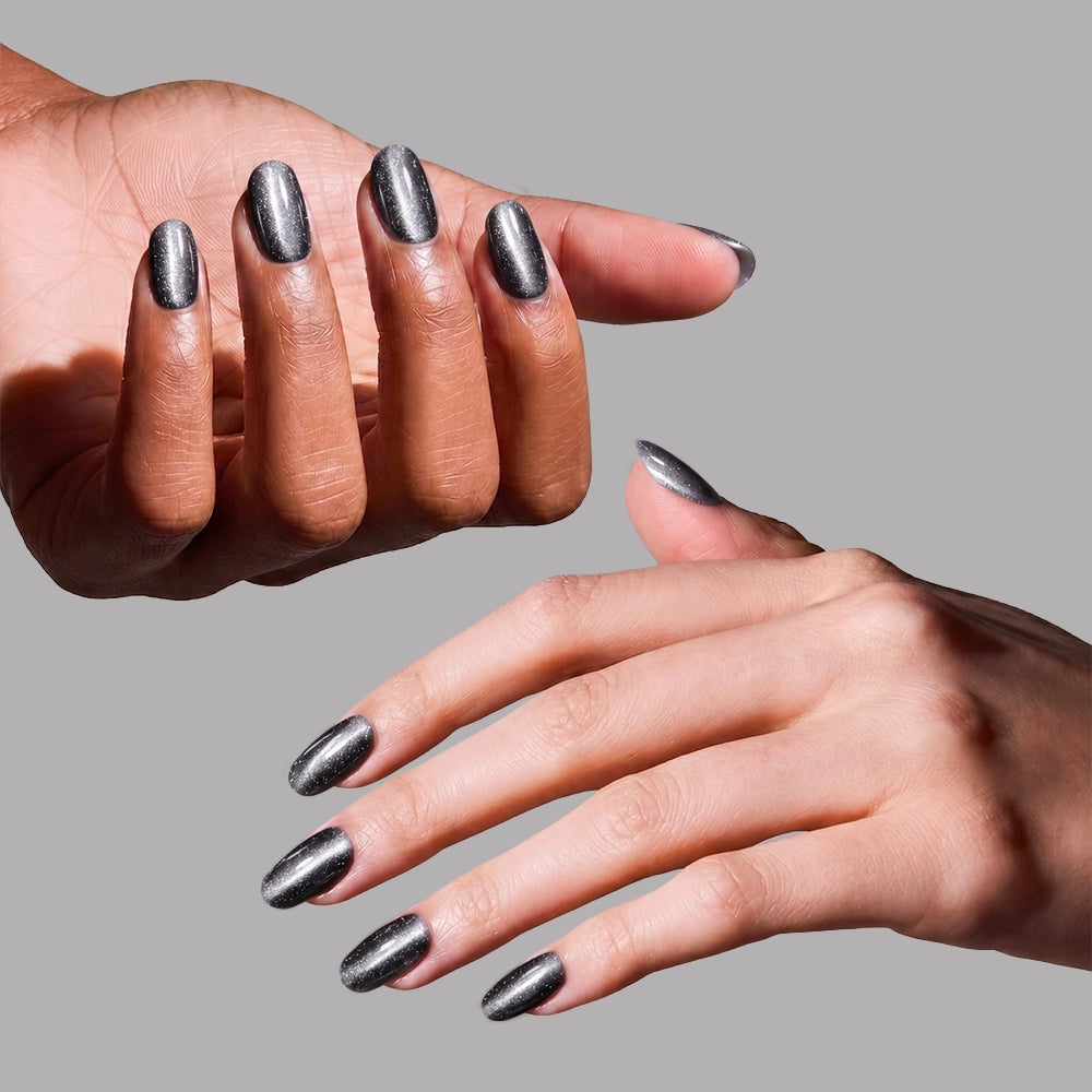 Two hands with neat, short round press-on nails in shiny metallic gray (Galactic by glamnetic)—one with a darker skin tone and one lighter—are shown on a plain gray background. These vegan nails offer a stylish, salon-quality look. - Product image