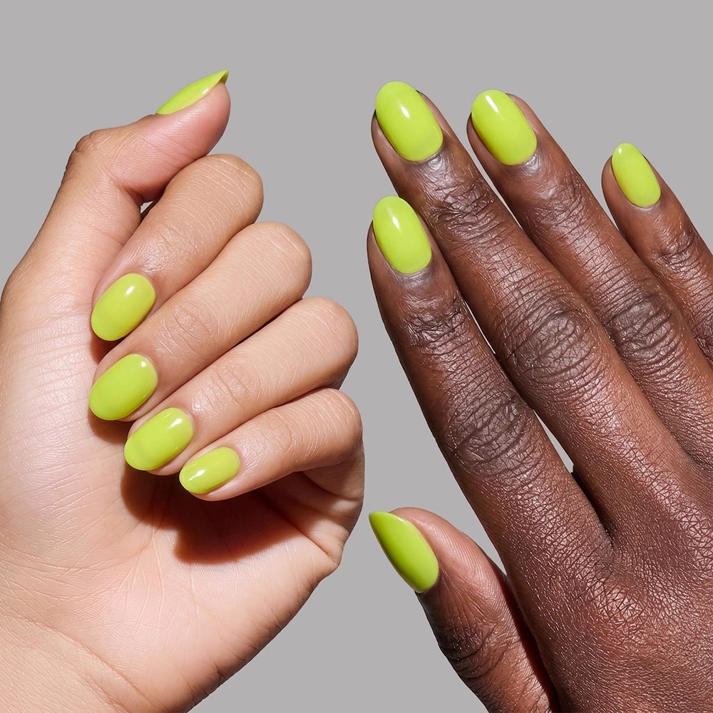 Two hands with different skin tones showcase glamnetic Lime Green press-on nails in a vibrant, glossy finish against a plain gray background. - Product image