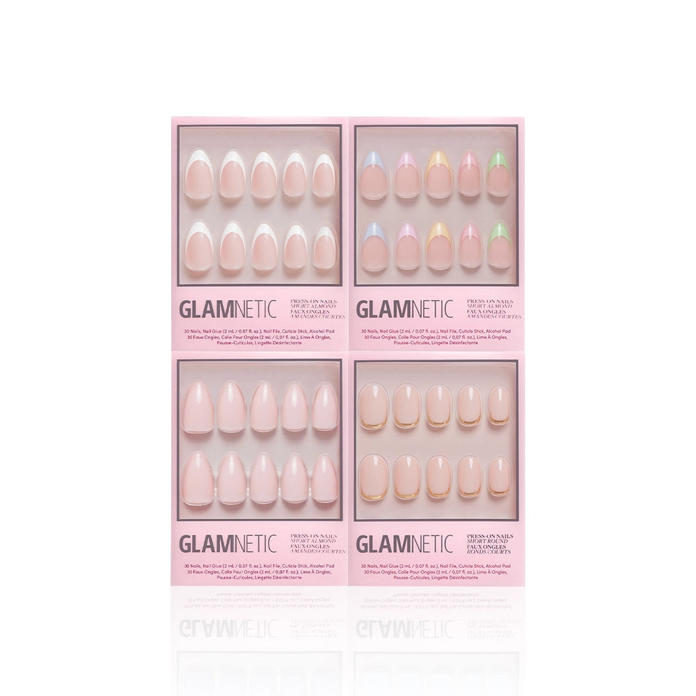 Four boxes of glamnetic's Nail Obsessed press-on nails are displayed on a white background, each in light pink packaging and featuring pastel-colored short almond or French tip sets with various subtle designs. - Product image