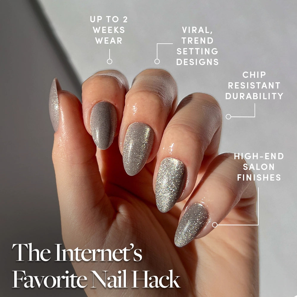 A hand flaunts Oslo by glamnetic—long, almond-shaped silver cat-eye nails with trendy designs and a salon-quality finish. Enjoy chip resistance and wear up to 2 weeks. The Internet’s Favorite Nail Hack is featured below. - Product image