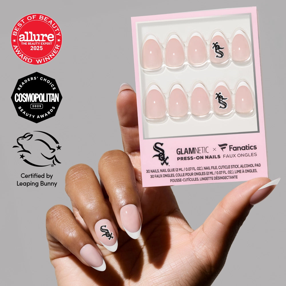 A hand with light pink, neatly manicured Chicago White Sox Press-On Nails by glamnetic holds a box of the officially licensed set, with beauty and cruelty-free certification logos shown on the left side.