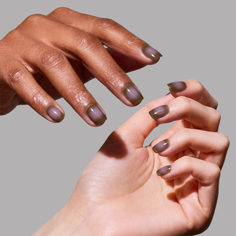 Two hands with different skin tones show off well-manicured, short squoval nails in matte olive green "Eclipse" by glamnetic against a gray background. - Product image