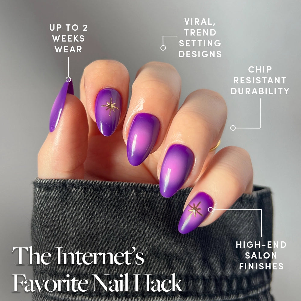 A hand with long, almond-shaped glamnetic Tarot press-on nails in a purple ombre with gold stars. Text highlights chip resistance, high-end finish, trendy design, and up to 2 weeks wear. - Product image