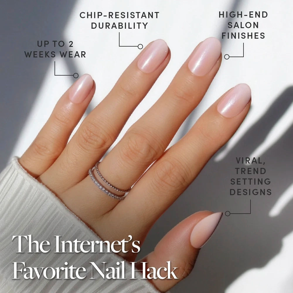A hand with neatly manicured, light pink short oval nails showcases stacked rings. Crystal Glaze by glamnetic offers chip-resistant durability, high-end finishes, up to two weeks wear, and stylish trendy designs. - Product image