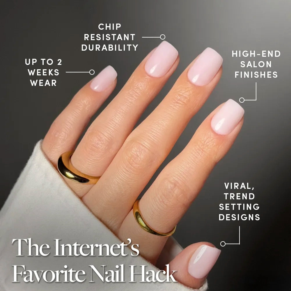A hand with short, light pink squoval nails wears two gold rings. glamnetic Soft Girl press-ons offer salon-quality mani: chip-resistant durability, up to 2 weeks’ wear, high-end finishes, and viral designs. - Product image