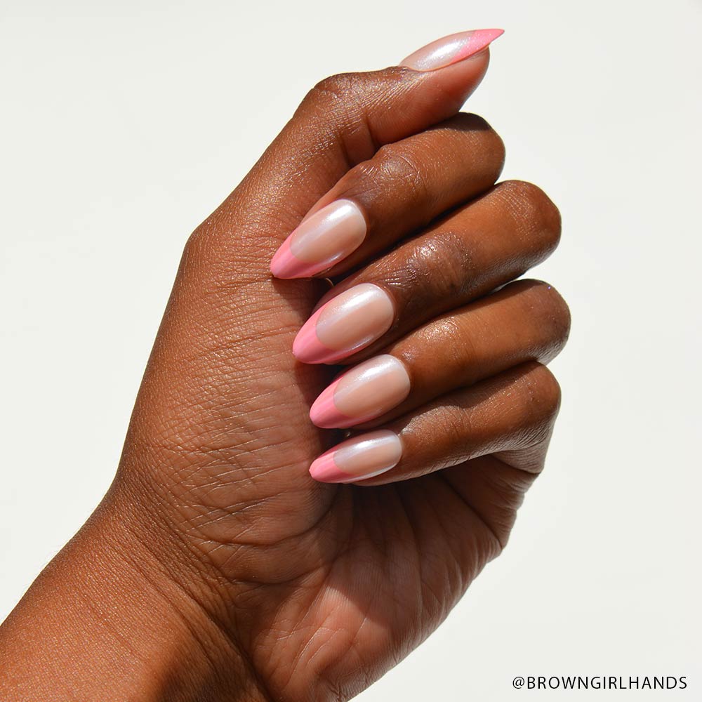 A hand with medium brown skin displays almond-shaped nails featuring glamnetics Bubble Gum Glaze French tips over a natural base. The background is plain white, with @BROWNGIRLHANDS in the bottom right corner. - Product image
