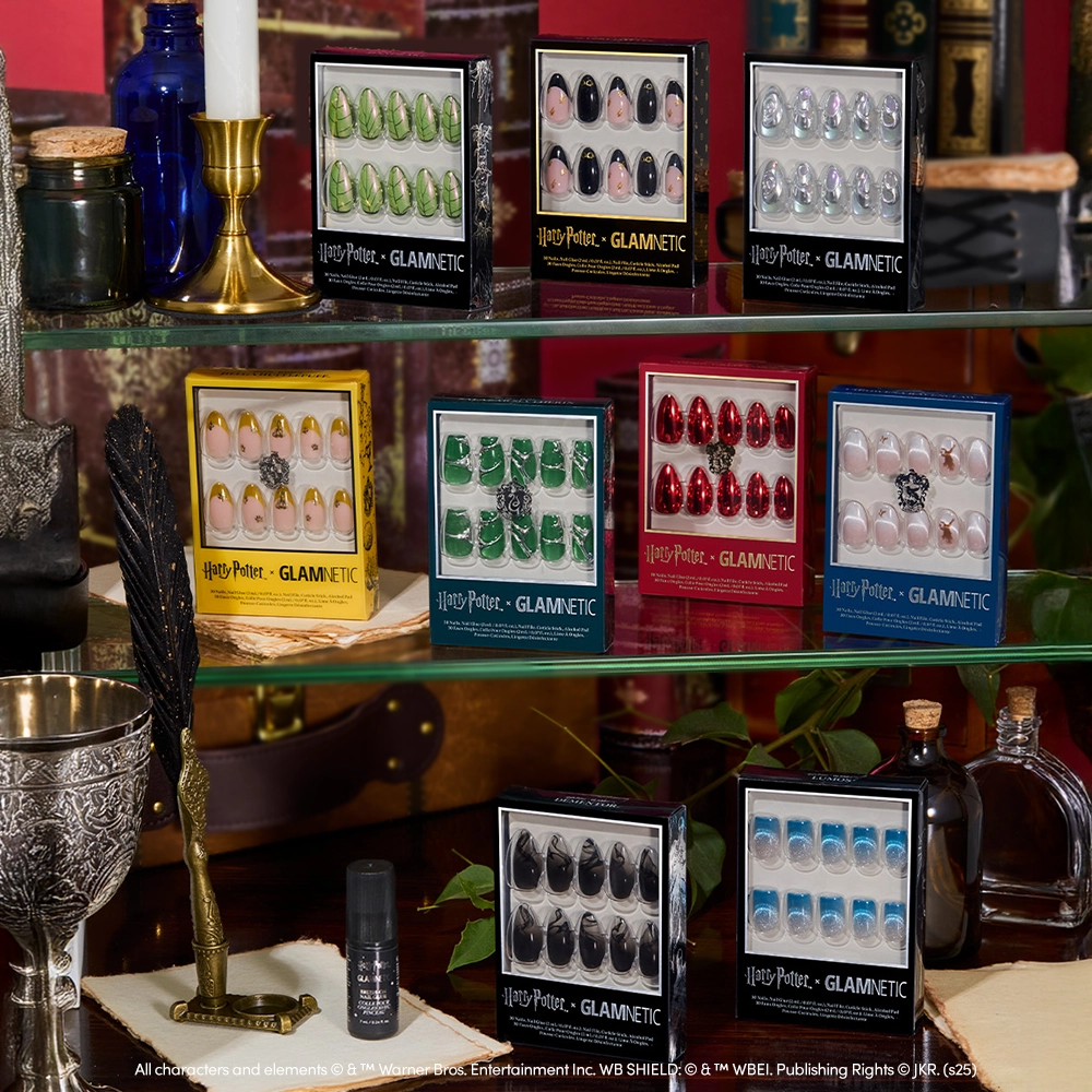 A display of glamnetic's Lumos press-on nail set is arranged on shelves decorated with books, candles, potion bottles, and magical creature stickers for a magical Harry Potter-inspired setting. - Product image