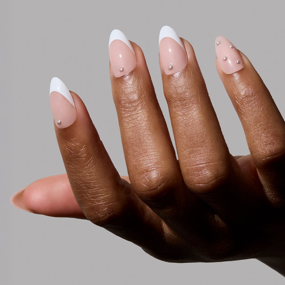 A close-up of a dark-skinned hand with the “Always & Forever” nails. The design includes white French tips and tiny pearls on a glossy nude base, highlighting the minimal yet chic style.
- Product image