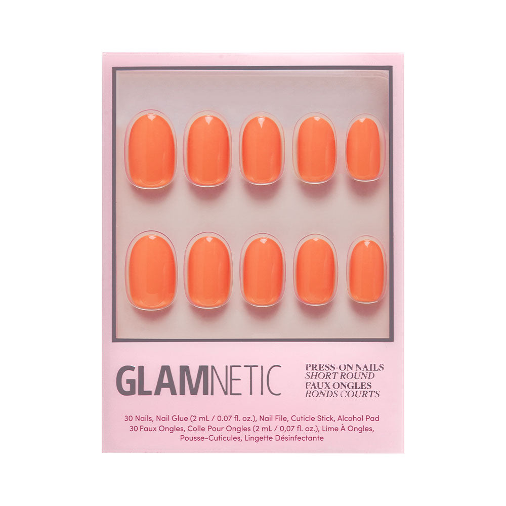The Apricot press-on nails by glamnetic include 10 short, round orange nails on a pink card, plus nail glue, file, cuticle stick, and alcohol pad for easy application. - Product image