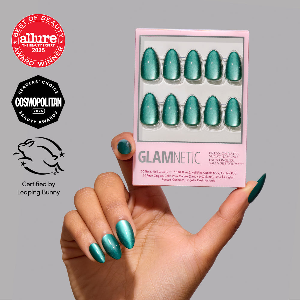 Arctic Aurora - A hand displays metallic emerald green short almond Arctic Aurora nails next to a product box featuring the same design, with Allure and Cosmopolitan award seals and a Leaping Bunny certification logo in the corner.
