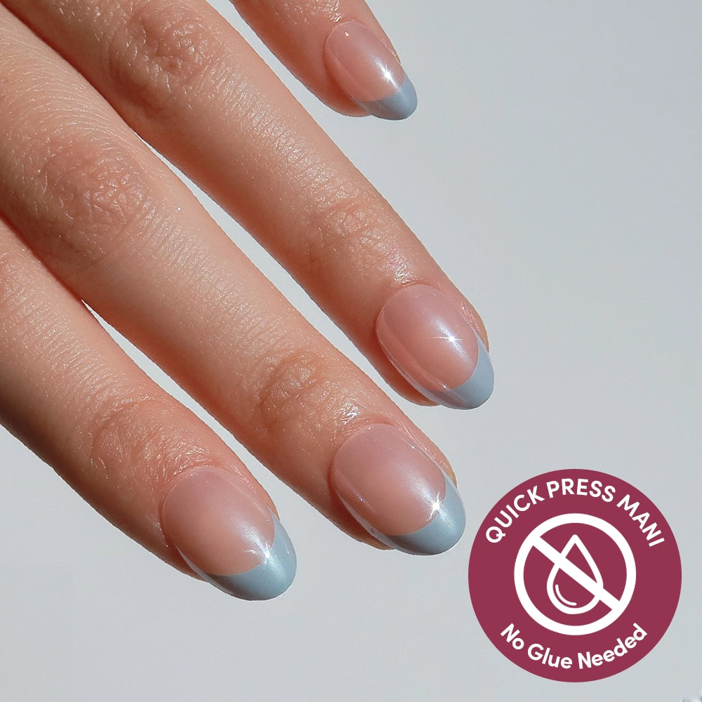 A hand displays glamnetic Blue Halo press-on nails with a sheer pink base and light blue French tips. A badge reads QUICK PRESS MANI No Glue Needed.