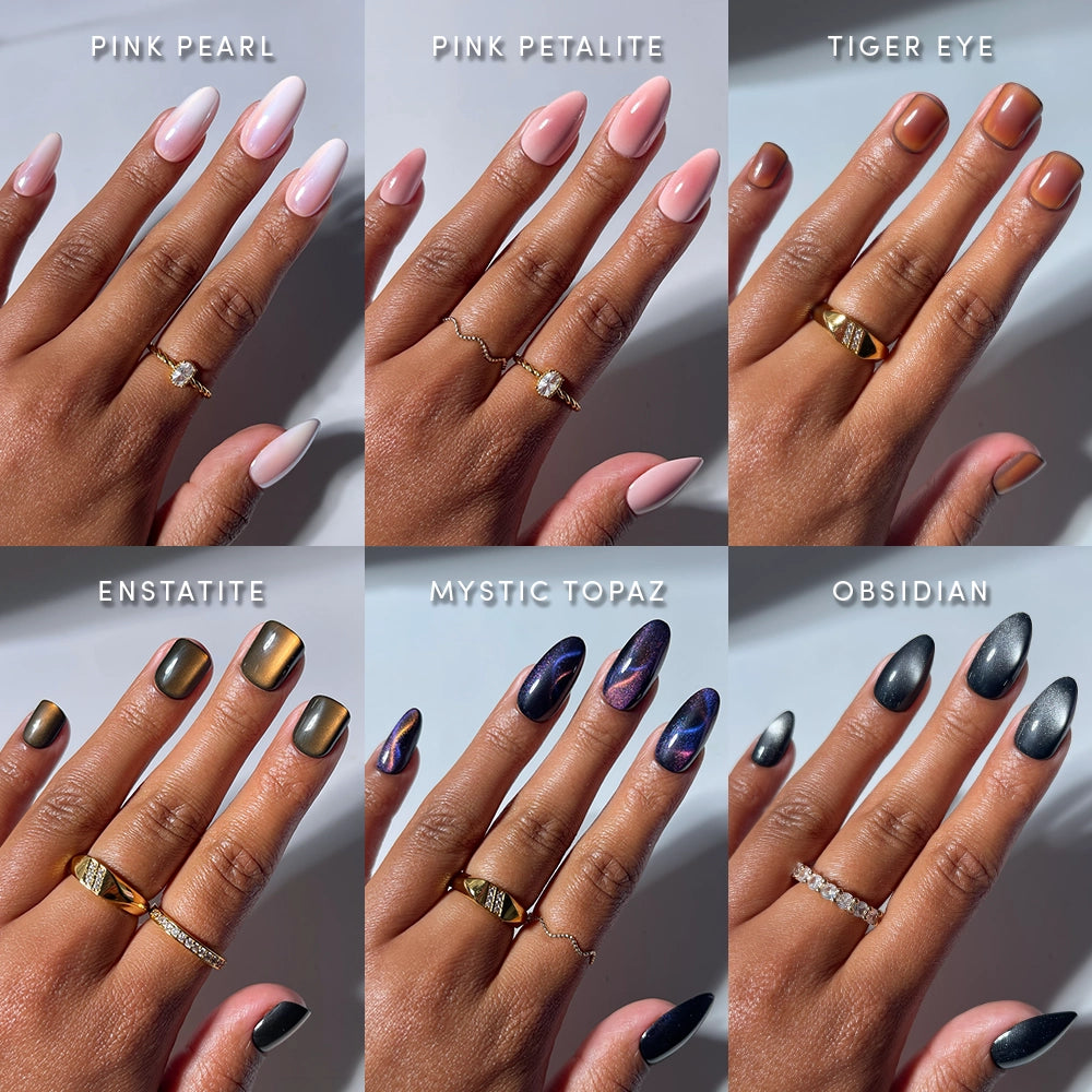 Six hands display a variety of manicures—light pink, bright pink, peachy brown, metallic gold, iridescent purple, and matte black—each featuring glamnetic’s Bare Gems almond-shaped press-on nails adorned with rings. This image showcases labeled nail shades from the Bare Gems collection by glamnetic, offering inspiration for fans of minimalist manis as well as those who love a touch of sparkle.