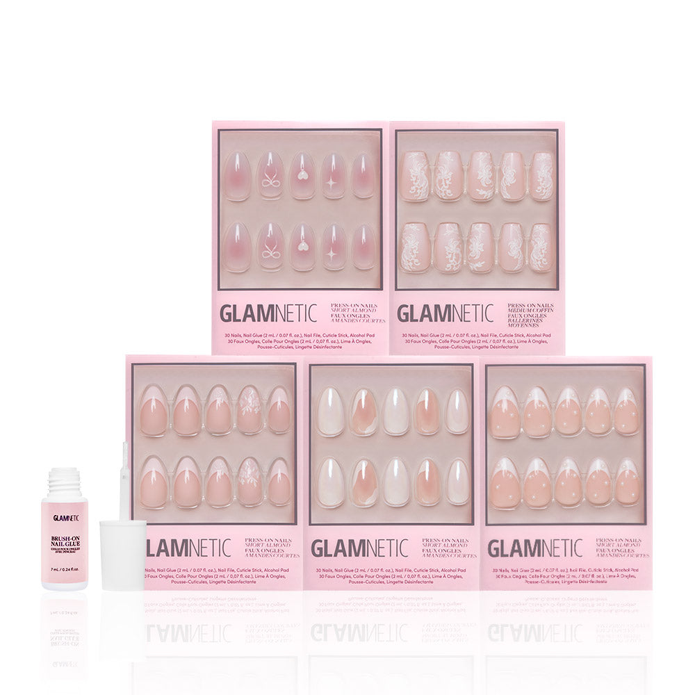 Six sets of glamnetic Be Mine pink and white press-on nails, featuring short almond French tip designs and semi-transparent accents, are displayed in two rows in pink glamnetic boxes. A small bottle of nail glue with an open cap sits on the left. - Product image