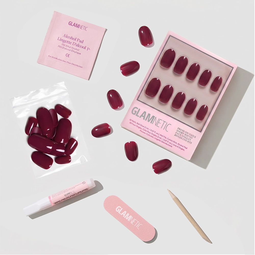 The glamnetic Berry Maroon Nail Set includes burgundy press-ons, a pink file, cuticle stick, alcohol pad, nail glue, and extra nails—all showcased as part of our autumn collection against a crisp white background. - Product image