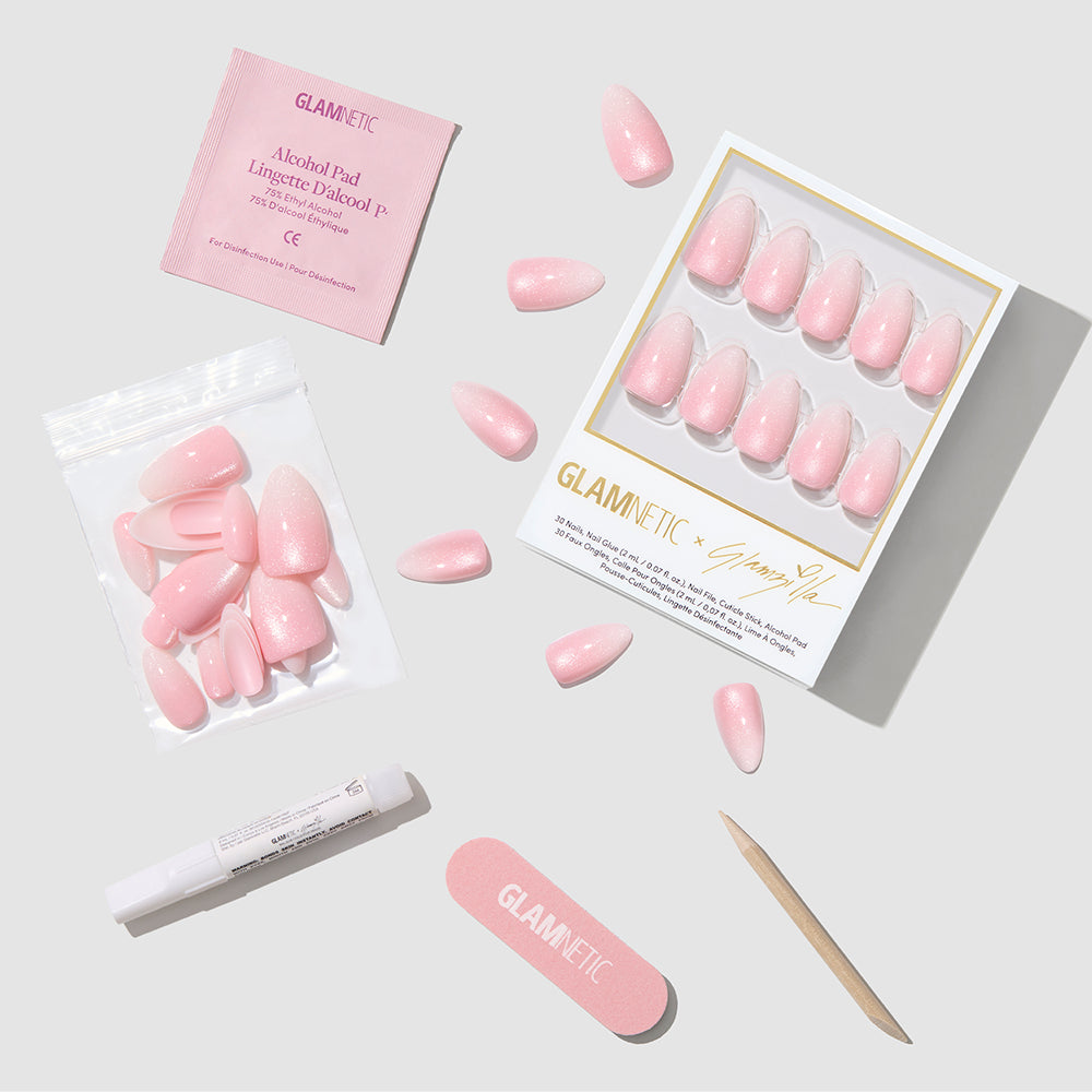 The glamnetic BIG BUNNY ENERGY set features short almond baby pink press-on nails, a nail file, wooden cuticle stick, adhesive tube, alcohol pad, and extra nails arranged neatly on a light gray surface. - Product image