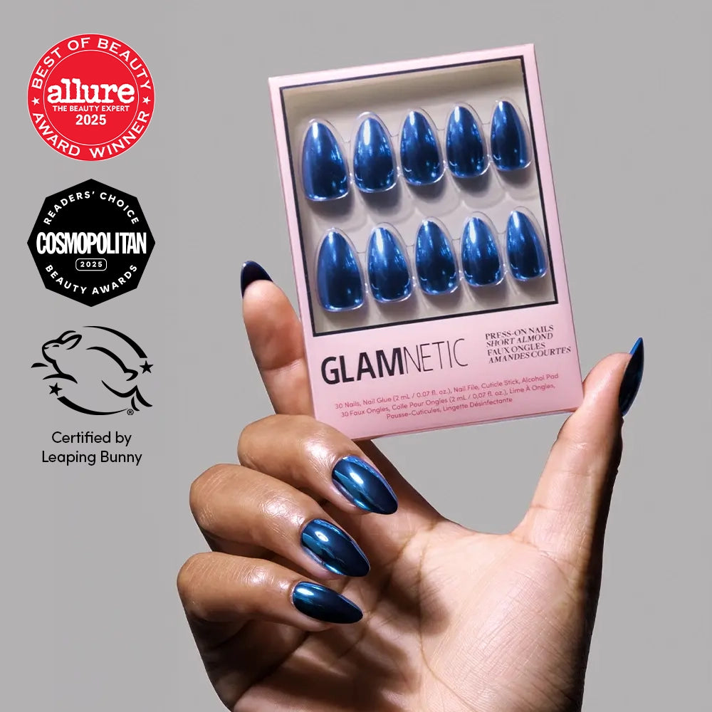 Blue Steel - A hand holds a box of Glamnetic Blue Steel short almond press-on nails in metallic blue, featuring Allure and Cosmopolitan award seals and a Leaping Bunny certification logo.