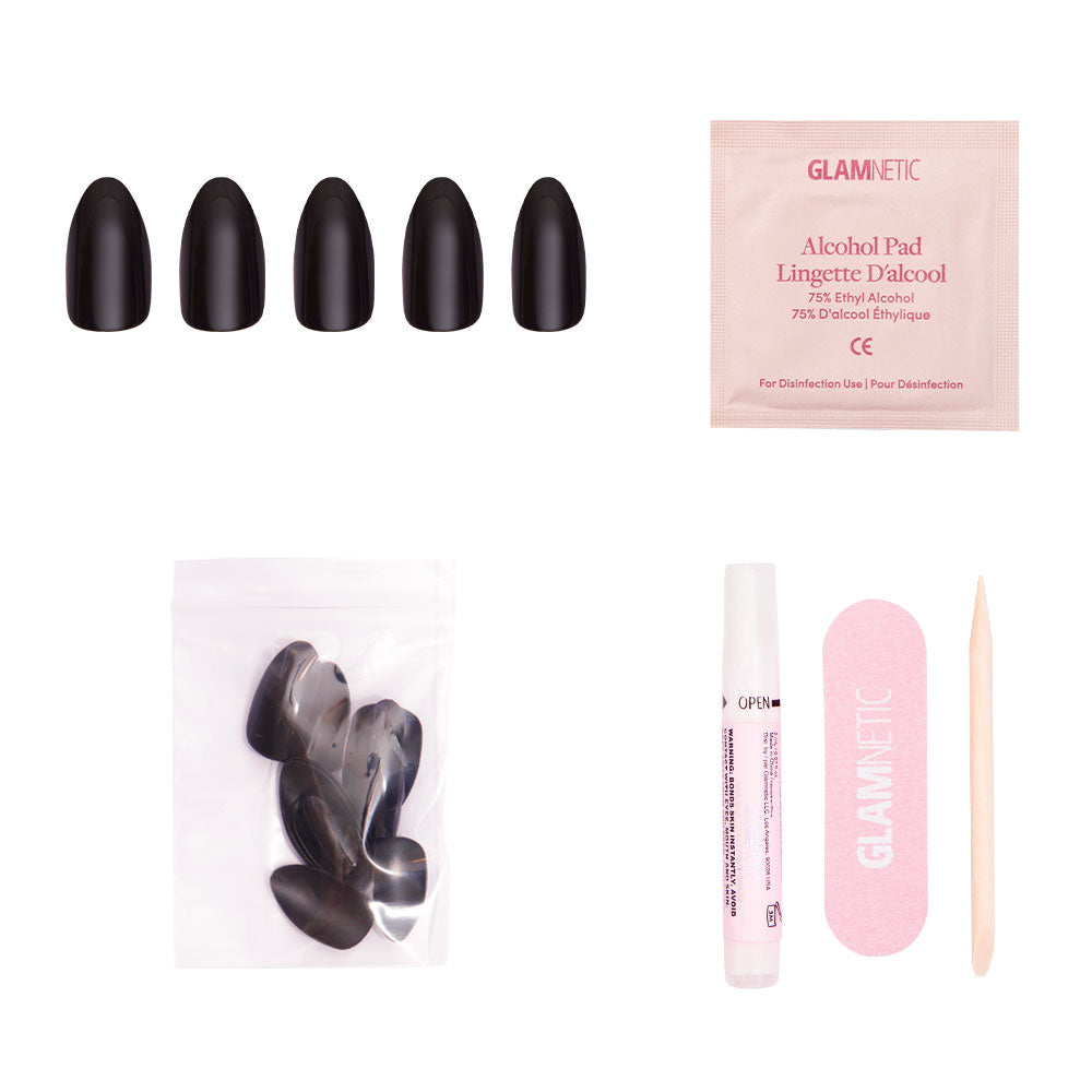 The glamnetic Boba kit includes almond-shaped black press-on nails, an alcohol pad, extra nails, nail glue tube, pink nail file, and wooden cuticle stick, all displayed on a white background. - Product image