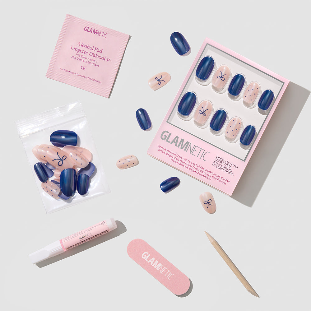 Bows & Bits - Glamnetic Bows & Bits short round press-on nails in navy blue and polka-dot patterns, displayed in a box with glue, an alcohol pad, a nail file, and a cuticle stick.
