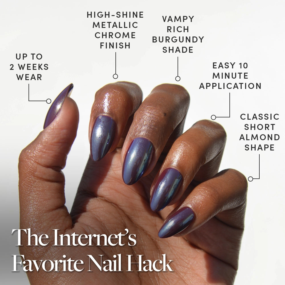 A hand with short almond glamnetic Burgundy Chrome nails in metallic purple is shown against a white background. These reusable press-ons deliver viral designs and a salon-quality finish for up to two weeks—the Internet’s Favorite Nail Hack. - Product image
