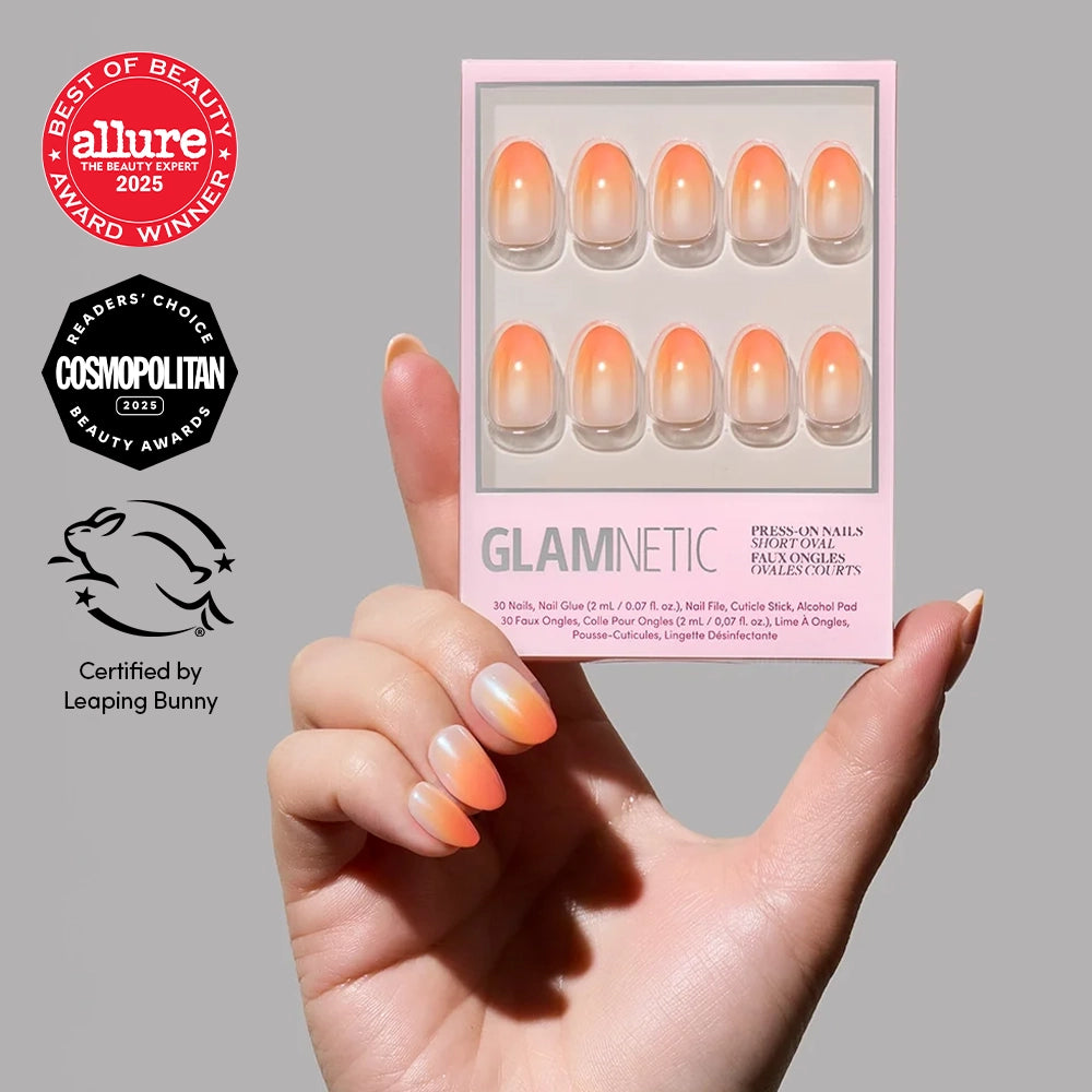 A hand holds a pack of Candy Corn press-on nails by glamnetic, perfect for Halloween. Beauty award badges and a Leaping Bunny cruelty-free logo are shown next to the product. - Product image