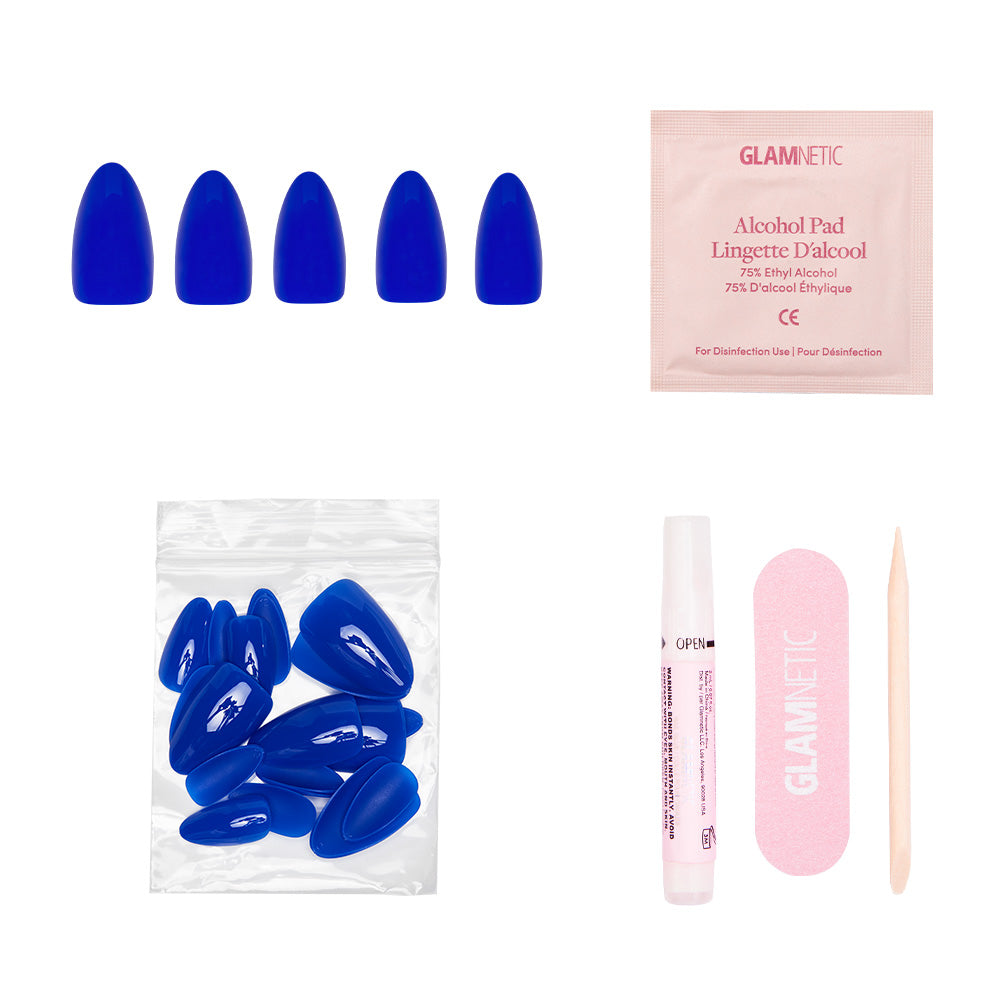 The glamnetic Cobalt Blue set features short almond nails, extra nails, an alcohol pad, nail glue, a pink file, and a cuticle stick—perfect for summer adventures—all arranged on a white background. - Product image