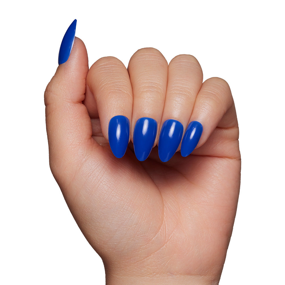A hand with short almond-shaped nails painted in glamnetics Cobalt Blue shines with a glossy finish, perfect for summer adventures, set against a plain white background. - Product image
