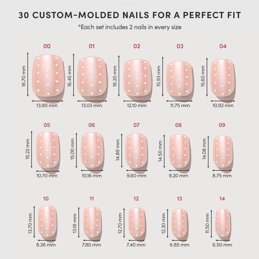 Chart displays 15 sizes of glamnetic Dainty Dots custom-molded press-on nails (sizes 00–14), two no-glue nails per size, each nail's height and width shown over a pink background with white polka dots. - Product image
