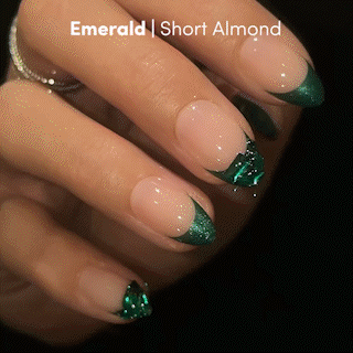 Short almond-shaped press-on nails from glamnetic in the style “Emerald,” featuring a glossy nude base, emerald green French tips, and shiny green foil accents for a luxurious, salon-quality finish.