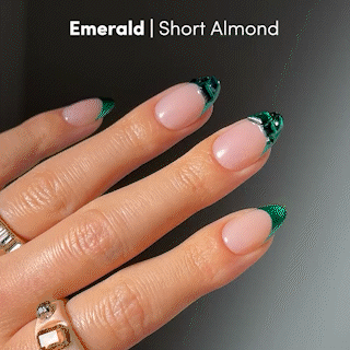 Short almond-shaped press-on nails from glamnetic in the style “Emerald,” featuring a glossy nude base, emerald green French tips, and shiny green foil accents for a luxurious, salon-quality finish.
