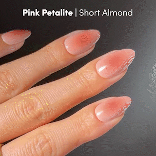 A hand with short almond-shaped nails, featuring a gradient from pale pink to deep rose, displays the stunning glamnetic Pink Petalite press-on nails. At the top, the text "Pink Petalite | Short Almond" is shown.