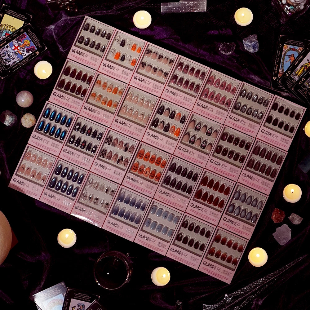 A display of glamnetic’s Dark Waters boxed press-on nails is showcased amidst lit candles, tarot cards, crystals, and draped with a dark cloth, creating a mystical and decorative ambiance that highlights the long-lasting allure of these enchanting nails. - Product image