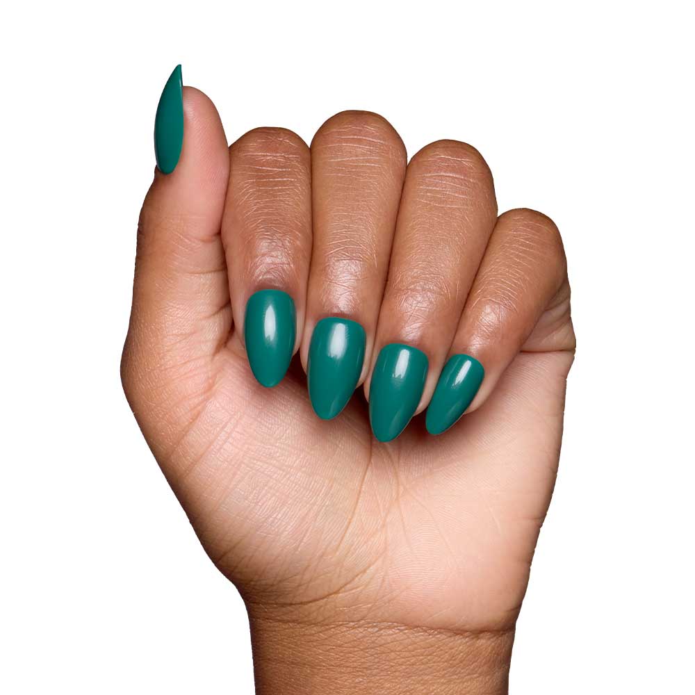 A medium skin tone hand forms a fist, showcasing glamnetics Emerald Green short almond nails with a glossy finish against a white background. - Product image