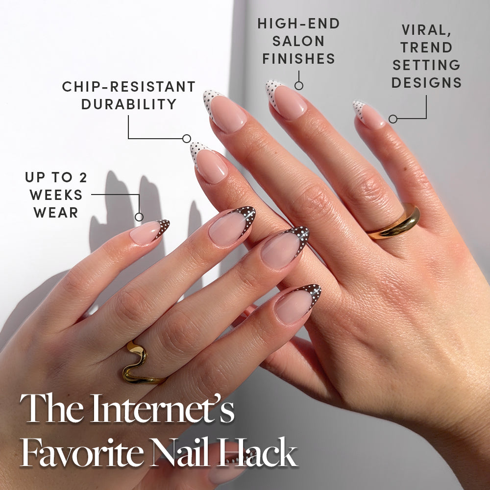 Hands with almond-shaped nails in Polka In Positano by glamnetic, featuring a nude base and black-and-white dotted French tips. Enjoy salon-quality, trendy style, customizable wear, and up to two weeks of flawless durability. - Product image