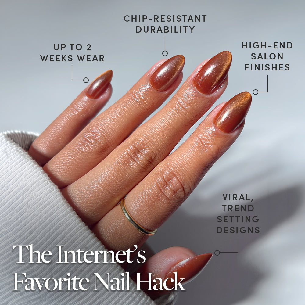 A close-up of a hand shows "Sicilian Sun" by glamnetic—shiny brown short almond press-ons with viral, trend-setting designs. These cruelty-free nails offer chip-resistant durability, high-end salon finishes, and up to 2 weeks’ wear. - Product image