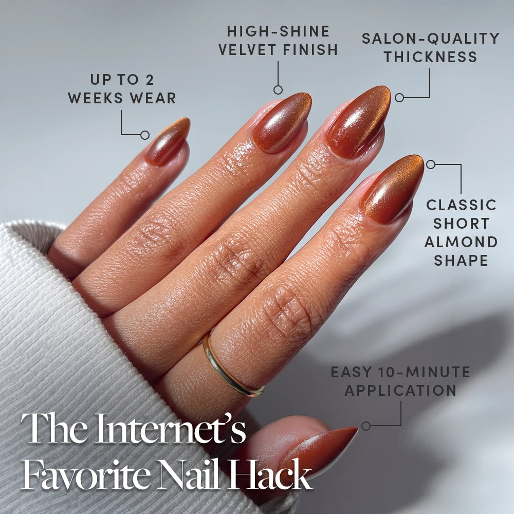 A close-up of a hand shows "Sicilian Sun" by glamnetic—shiny brown short almond press-ons with viral, trend-setting designs. These cruelty-free nails offer chip-resistant durability, high-end salon finishes, and up to 2 weeks’ wear. - Product image