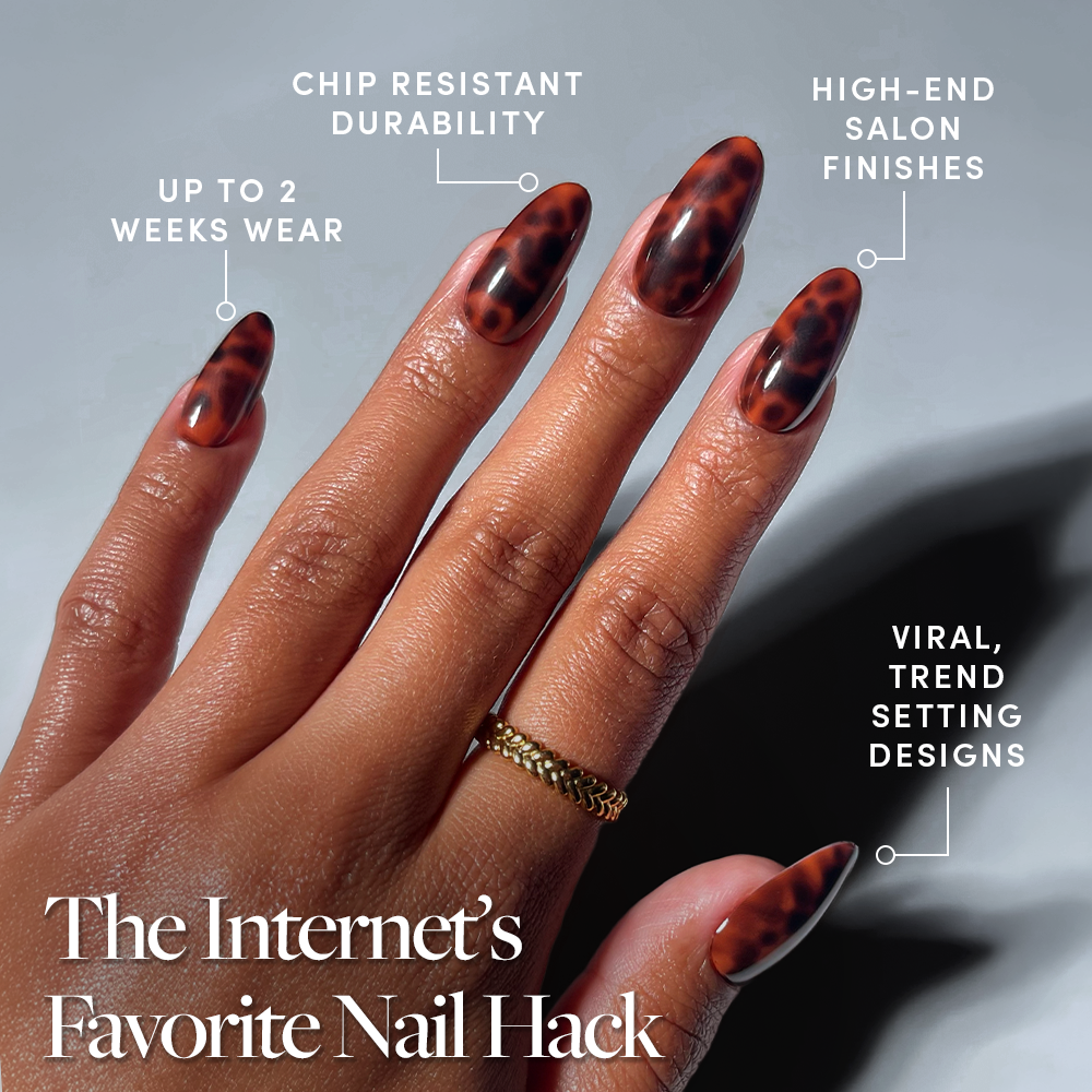 A hand with almond-shaped, brown tortoiseshell nails is shown. Text highlights salon-quality, chip-resistant durability, high-end finish, viral designs, and up to 2 weeks wear from glamnetic Expensive Taste Press-On Nails. - Product image
