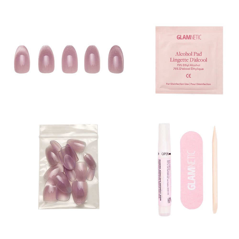 The glamnetic Fairy Dust set includes mauve short oval press-on nails with a velvet metallic finish, plus an alcohol pad, extra nails, glue, a pink nail file, and a wooden cuticle stick—all on a white background. - Product image