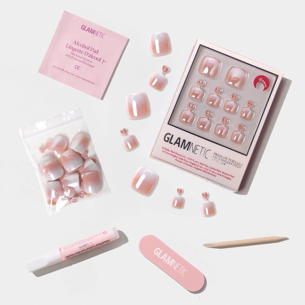 A flat-lay of the Glamnetic iridescent pink ombré press-on toenail kit with all included tools and accessories. - Product image