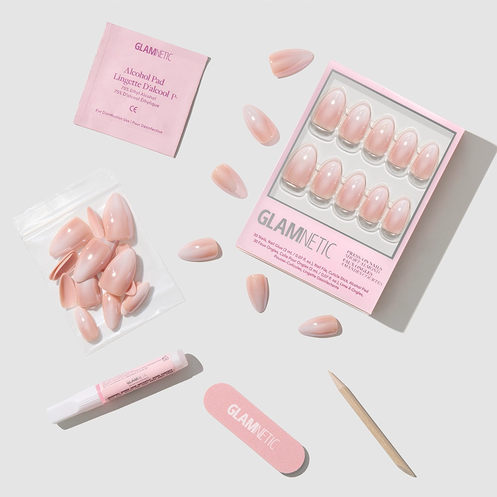 The glamnetic Fiancéd set features pink press-on nails, a nail file, a wooden cuticle stick, nail glue, an alcohol pad, and extra nails—organized together for easy use. - Product image