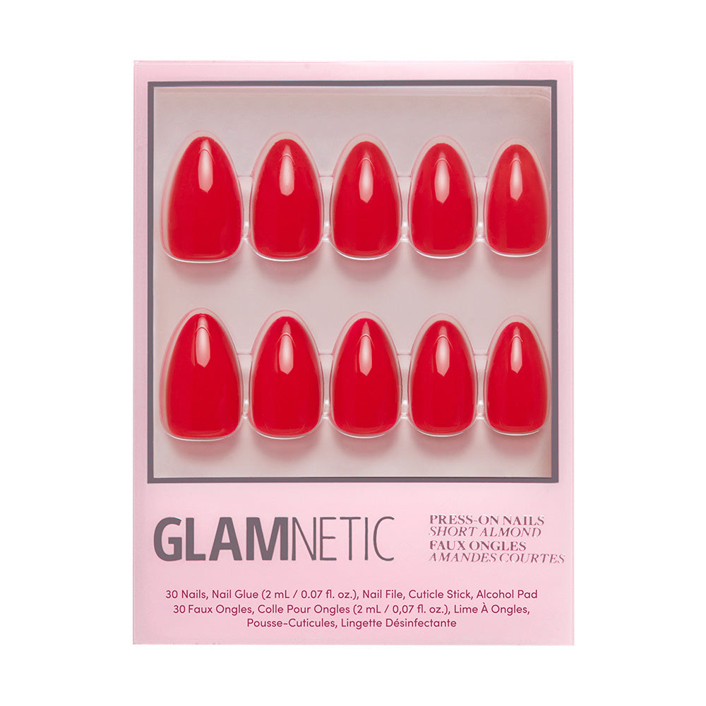 A package of glamnetic Fiery Red press-on nails in a bold summer color, arranged in two rows inside a pink box for short almond shapes. Includes nail glue and alcohol pad as listed on the packaging. - Product image