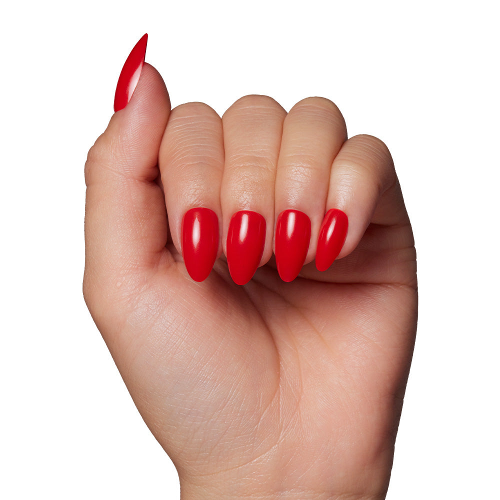 A hand with medium-length, almond-shaped nails painted in glossy glamnetic Fiery Red nail polish, making a bold summer statement against a plain white background. - Product image